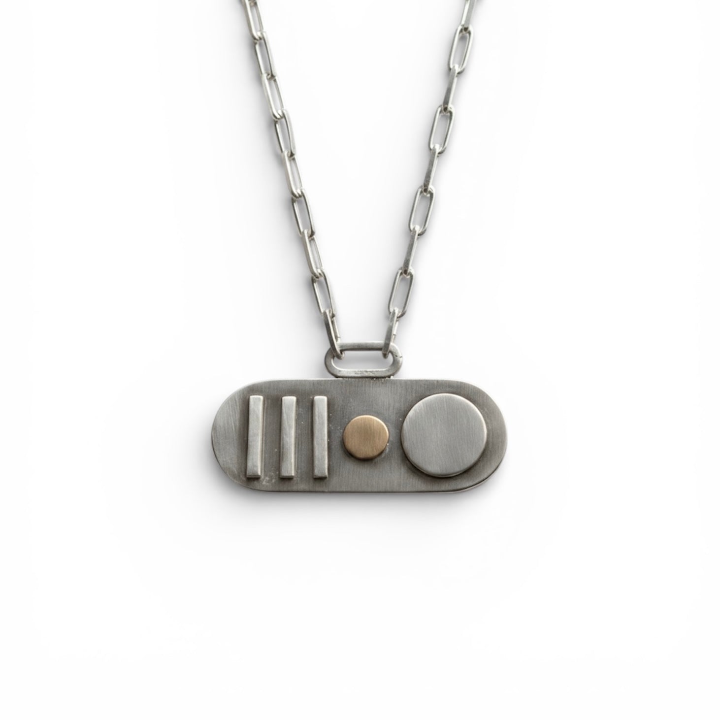 A handmade bespoke silver and 18ct gold oval necklace with 3 vertical line elements an 18t gold round element and a sterling silver larger round element hanging on a paperclip chain