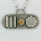 Sterling silver and gold pendant with geometric shapes and a paperclip necklace chain on a light grey background sustainably made by Bottlebee in Nottingham