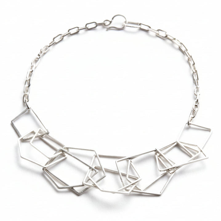 Silver geometric necklace handmade by Bottlebee in Nottingham placed on a white background