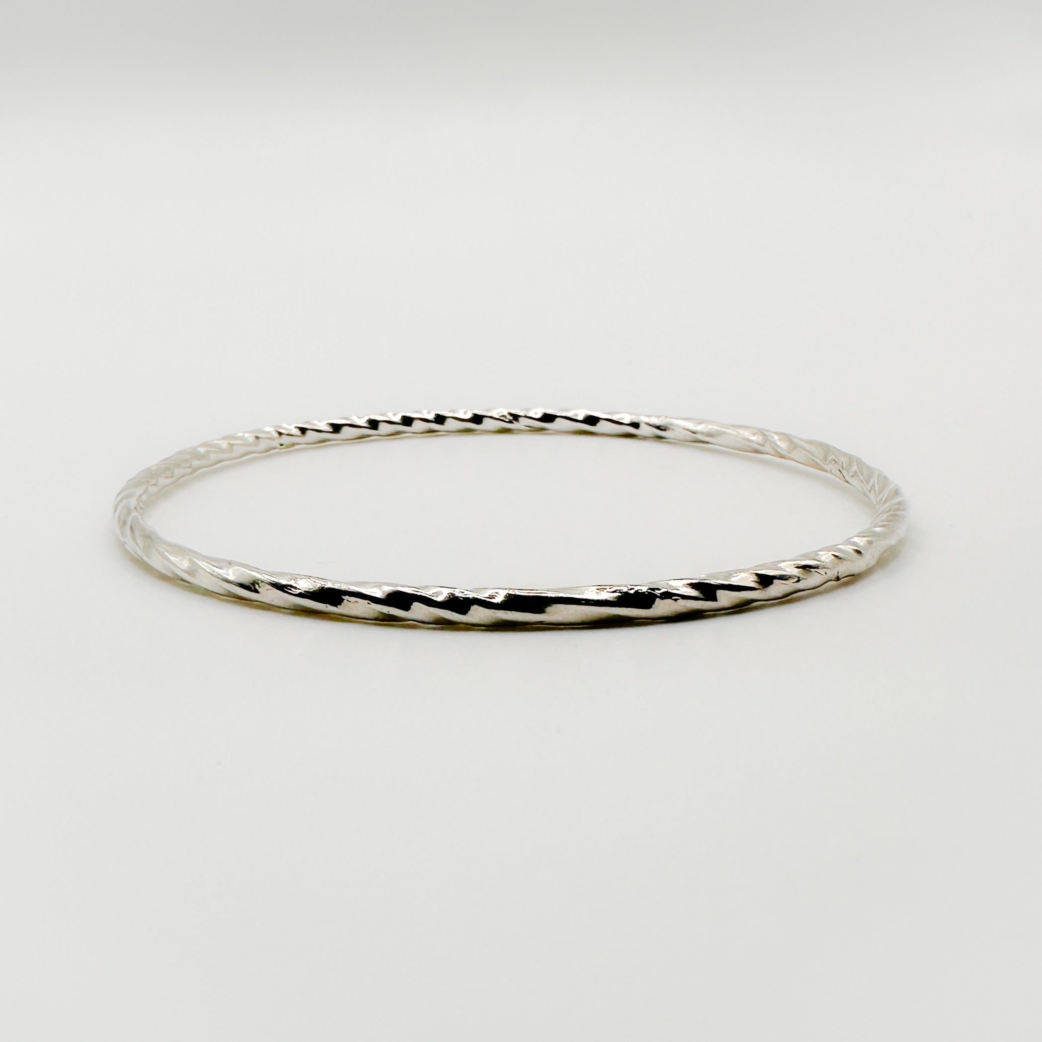 Sterling silver sustainable handmade jewellery bangle on a white background made by Bottlebee small business in Nottingham