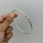 handmade silver bangle being held between asian fingers made by Bottlebee in Nottingham