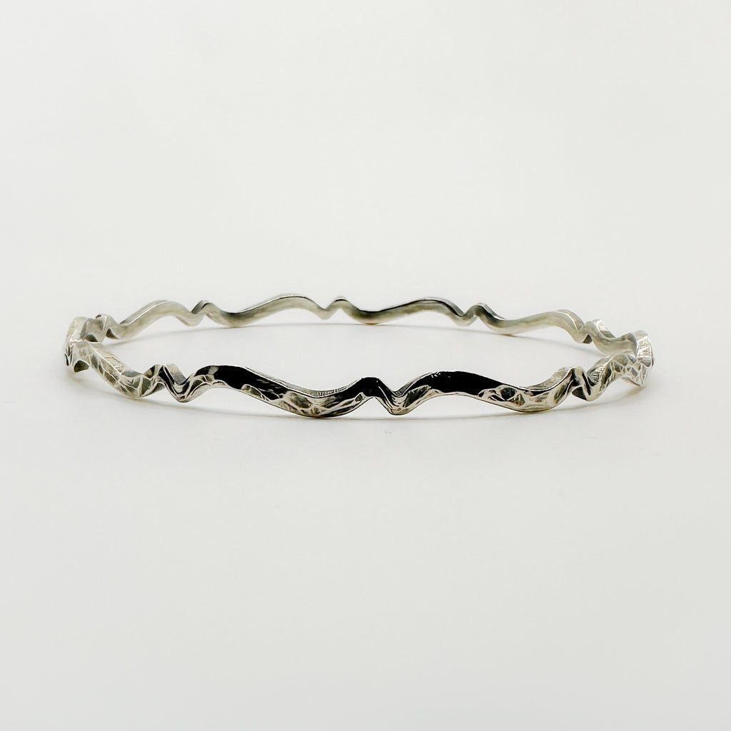 Sterling silver bracelet with wavy design on a white background handmade in Nottingham