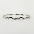 Sterling silver bracelet with wavy design on a white background handmade in Nottingham