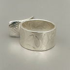 Silver ring with textured design on a gray background