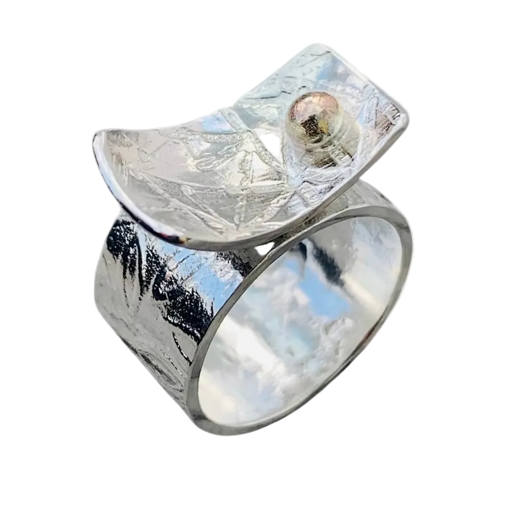 Silver ring with a textured surface and an 18ct gold ball on a white background handmade in nottingham by a sustainable jeweller