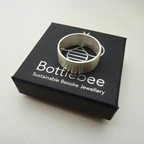 handmade silver mans wedding ring on a 'bottlebee' branded box on a white background