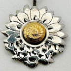 close up of butterflower Sterling silver and 18ct gold necklace with a sterling silver sunflower and butterfly shaped pendant on a white background. The butterflies are merging with the sunflower and the head of the sunflower in the middle of the pendant is made from 18ct gold. Handmade jewellery in Nottingham