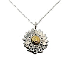 Sterling silver and 18ct gold necklace with a sunflower and butterfly shaped pendant on a white background. The butterflies are merging with the sunflower and the head of the sunflower in the middle of the pendant is made from 18ct gold. Handmade jewellery in Nottingham