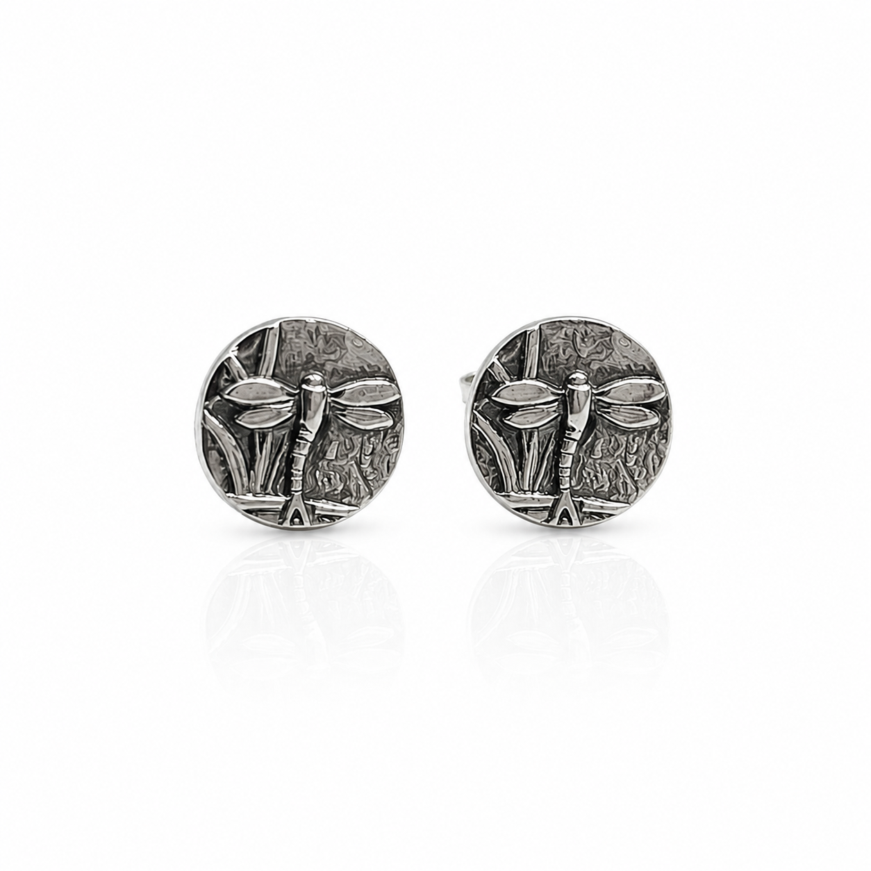 Pair of silver oxidised dragonfly stud earrings on a white background. Jewellery sustainable handmade in Nottingham by small business called Bottlebee