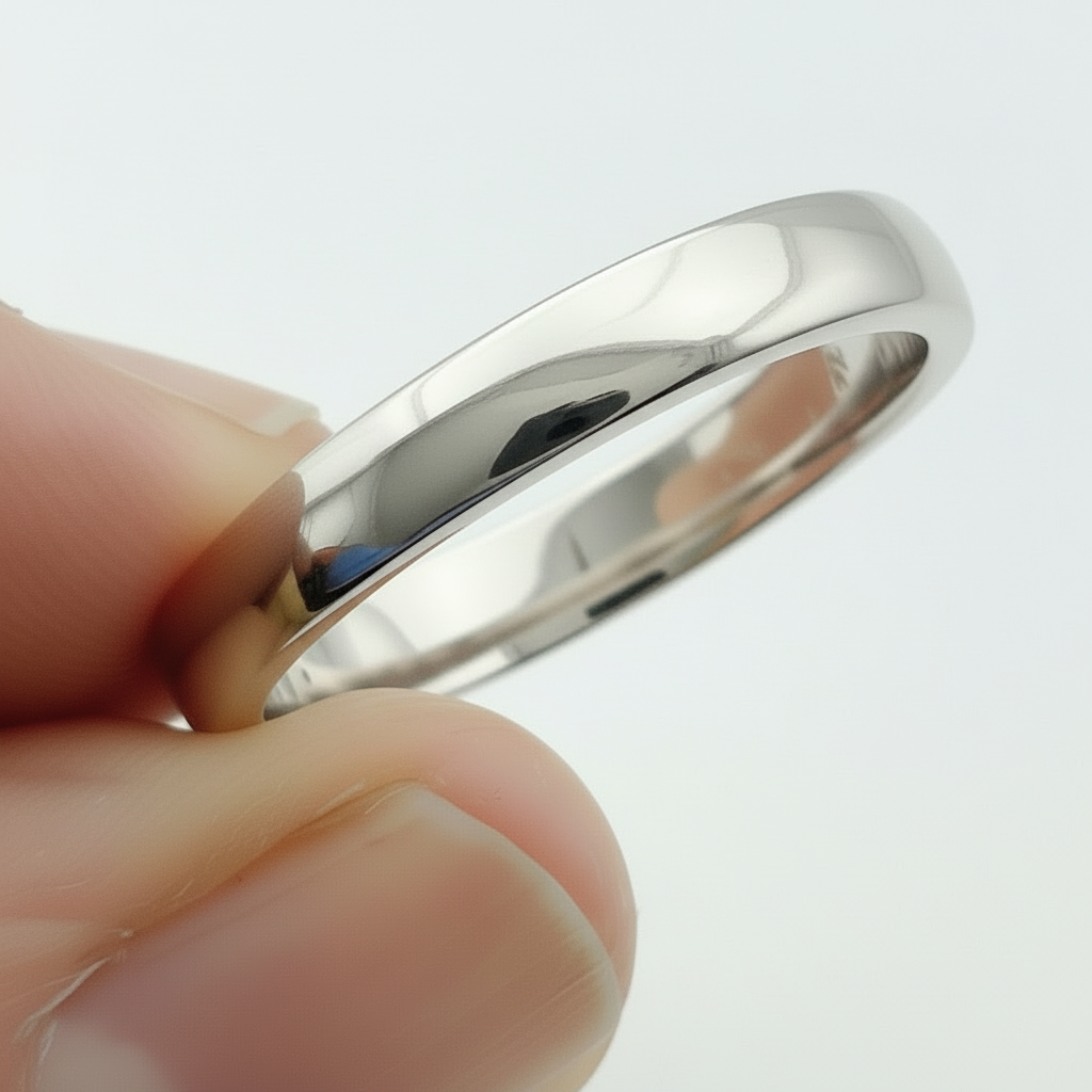 925 silver wedding ring held between fingers against a light background handmade bespoke sustainable jewellery nottingham