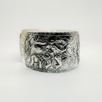 Silver cuff bracelet with intricate designs of elephants and giraffes on a white background made in Nottingham