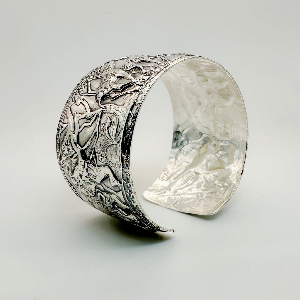 Silver cuff for man or woman with intricate animal design on a light background with giraffe and elephant