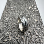 925 silver wedding ring band for a man woman or unisex with textured surface on a pattern plate used to make the design handmade sustainable bespoke jewellery Nottingham