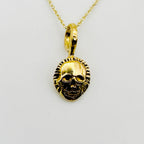 Gold skull pendant necklace on a light background