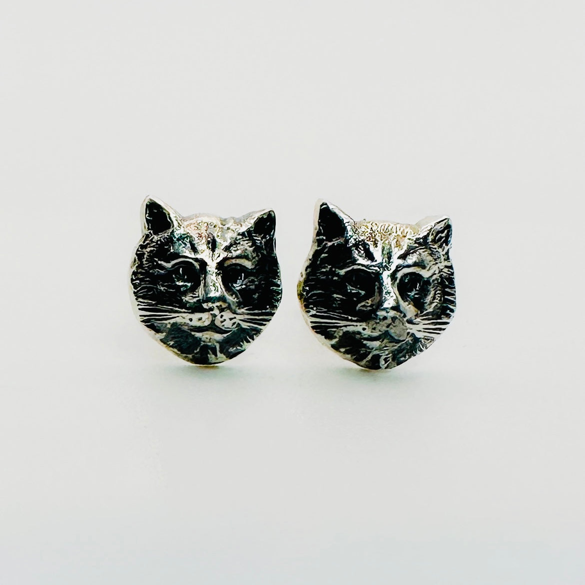 A pair of cat face stud earrings handmade by Bottlebee in Nottingham