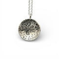 Silver necklace with a round pendant with thistles and flowers on a white background, handmade jewellery made by Bottlebee in Nottingham