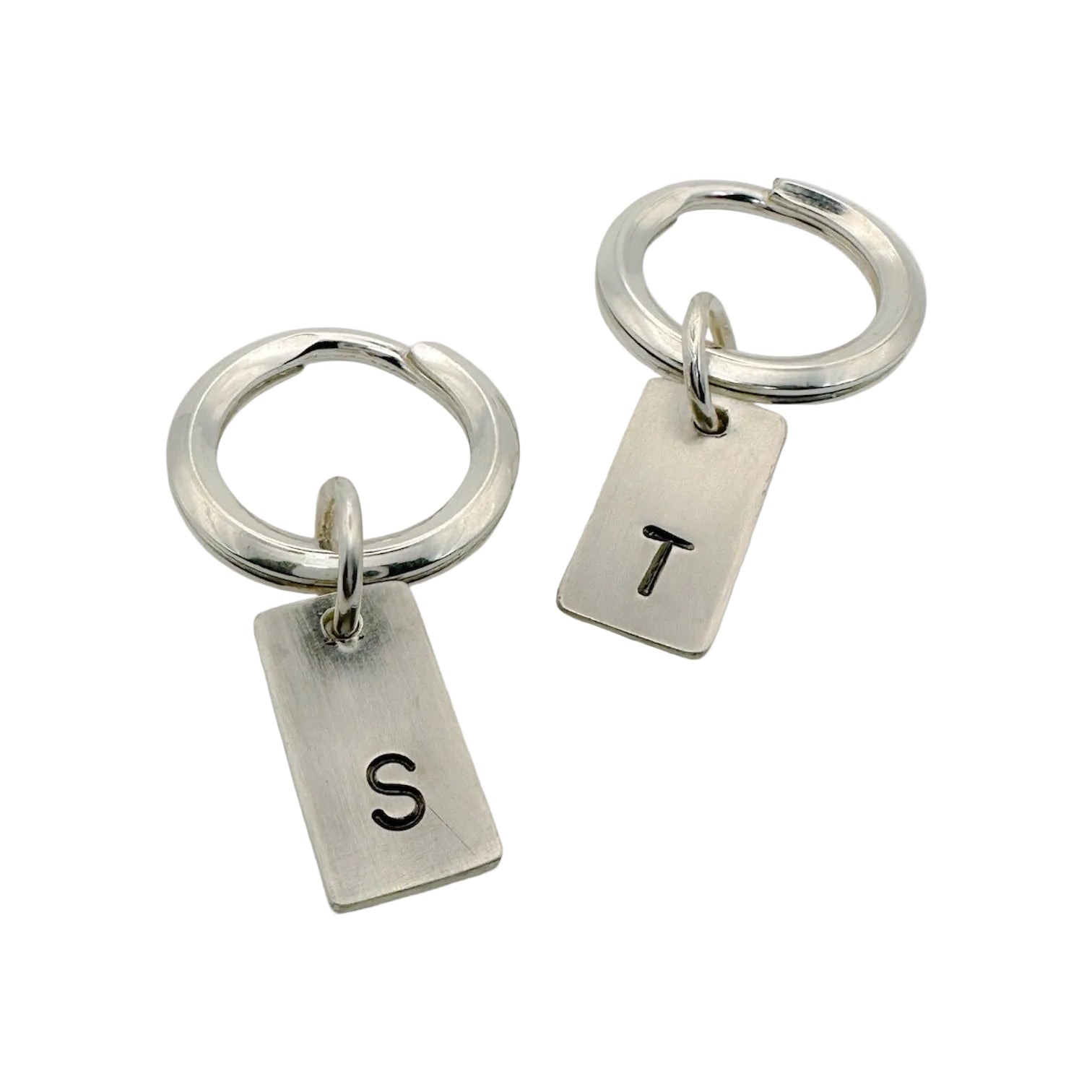 a pair of handmade sterling silver keyrings with hand stamped initials T and S made by a small independant jeweller in Nottingham