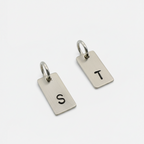 2 keyring tags made from sustainable sterling silver and hand stamped with an S and a T