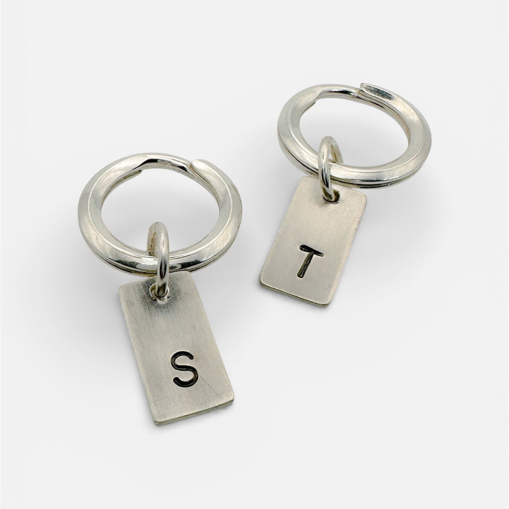 a pair of handmade sterling silver keyrings with hand stamped initials T and S made by a small independant jeweller in Nottingham