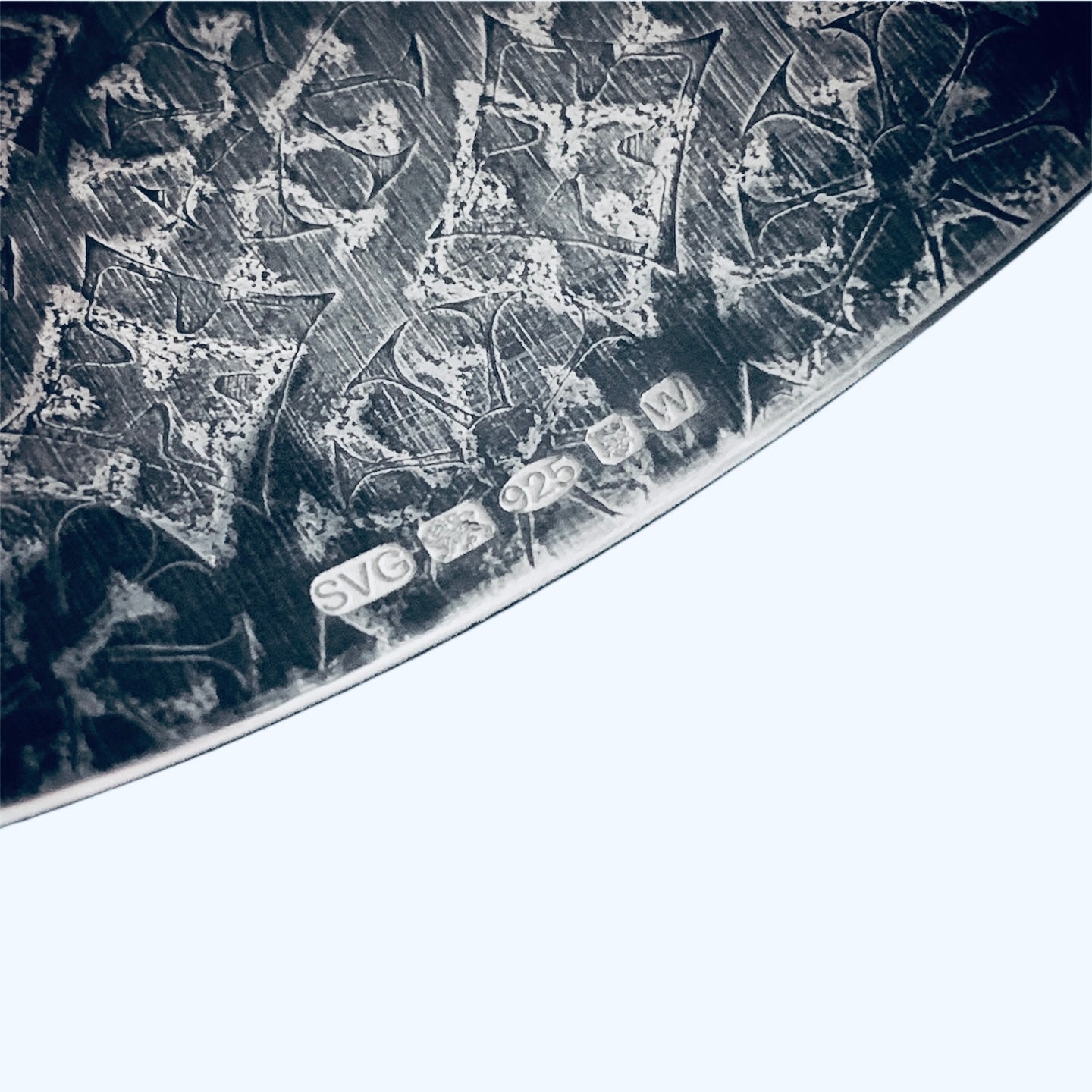 Close-up of a handmade bespoke cuff with art deco patterns and hallmark on white background made buy a small business based in Nottingham